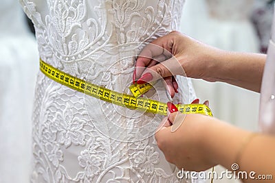 Measuring yellow tape with female hands and wedding dress Stock Photo