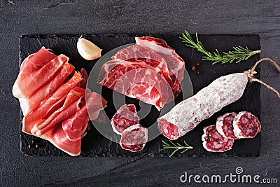 Meat appetizer platter with sausage, and cold cuts, above view on a slate serving board Stock Photo