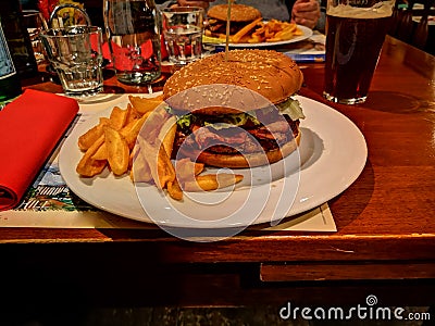 Meat burger with chips served on plate at the coveted table Stock Photo