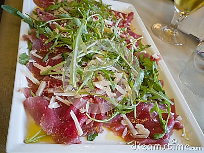 Meat Carpaccio with Rocket Salad and Cheese Flakes Stock Photo
