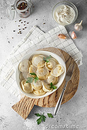 Meat dumplings - russian pelmeni, ravioli with meat on a white plate on a wooden background Stock Photo