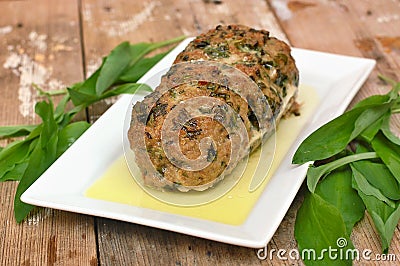 Meat loaf with fresh green buckrams leaves on white plate on wooden background Stock Photo