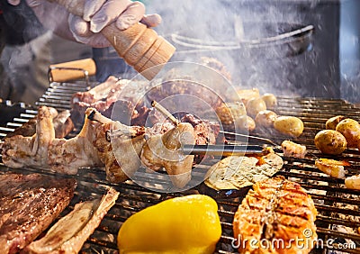 The meat is pickled on a lattice grill, ribs spread, a stake, Sausages, edges, chicken, naked flame, black pepper, a Stock Photo