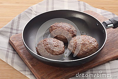 Meat rissoles on the frying pan Stock Photo