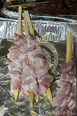 Meat sausages on wooden skewers in Ð°luminium packaging Stock Photo