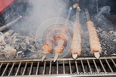 Meat skewers grilling over hot barbecue coals Stock Photo