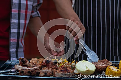 Meat and skewers ingredients for barbecue party are placed on grill to cook barbecue and make it ready for family to join barbecue Stock Photo