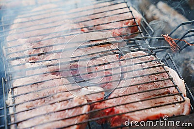 Meat steaks on a grill rack cooking over an open fire Stock Photo