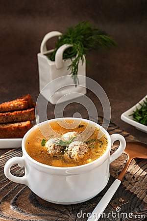 meatball soup. white broth on a wooden stand with delicious noodle soup with meatballs Stock Photo