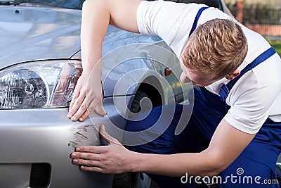 Mechanic assess the damage on the car Stock Photo