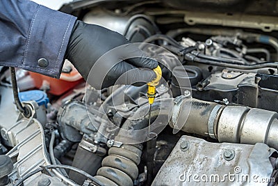 mechanic after change of oil in the engine checks level and quality on a probe Stock Photo