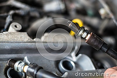 Mechanic changing broken car spark plugs. Stock Photo
