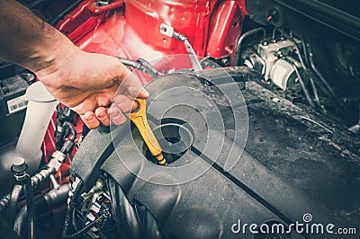 Mechanic checking the oil level in a car engine - retro style Stock Photo