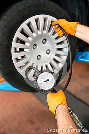 Mechanic checking tire pressure Stock Photo