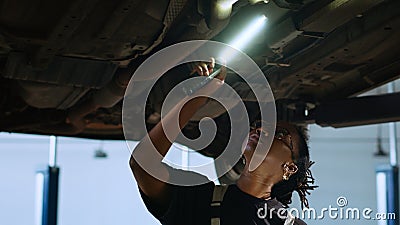 Mechanic checks car from underneath Stock Photo