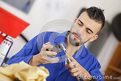 Mechanic cleaning auto part in workshop Stock Photo