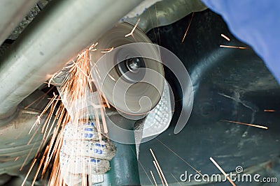 Mechanic cuts off the muffler in the car. Stock Photo