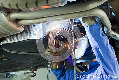 Mechanic cuts off the muffler in the car. Stock Photo