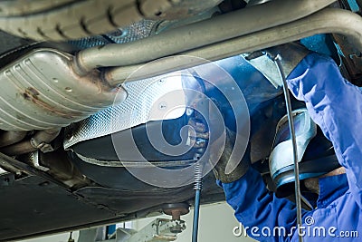 Mechanic cuts off the muffler in the car. Stock Photo