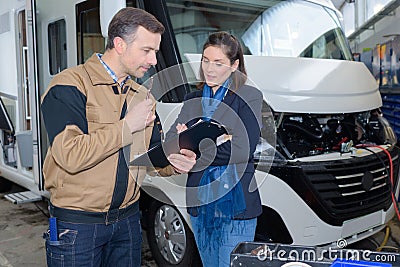 Mechanic discussing motorhome repairs with woman Stock Photo