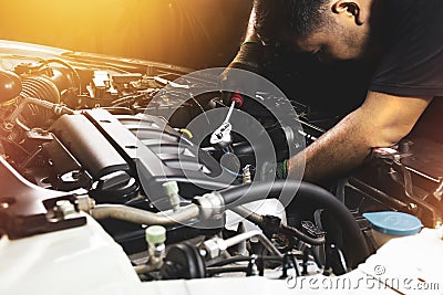 The Mechanic hand is fasten the bolt with the socket wrench to repairing of the car engine Stock Photo
