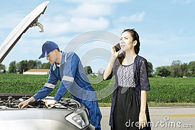 Mechanic with his panicky customer on roadside Stock Photo