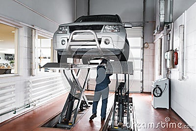 Mechanic inspect suspension system of lifted car Stock Photo