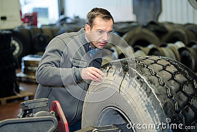 mechanic inspecting hgv tyre Stock Photo