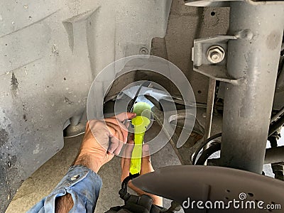Mechanic Inspecting Wheel Well with Flashlight Stock Photo