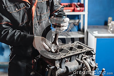 The mechanic installs a new piston. Disassemble engine block vehicle. Motor capital repair. Sixteen valves and four Stock Photo