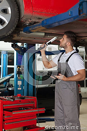 Mechanic Making an Inspection of a Car Chassis Stock Photo