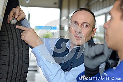 mechanic and male trainee working next to car together Stock Photo