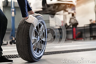 Mechanic man change a wheel tire and service maintenance the suspension of a vehicle Stock Photo