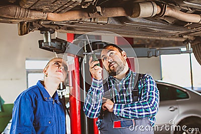 Mechanic man examining car with trainee girl Stock Photo
