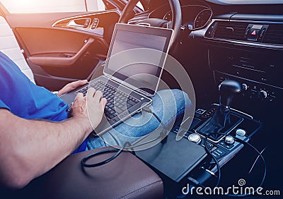 Mechanic man with laptop making car diagnostics at auto service Stock Photo