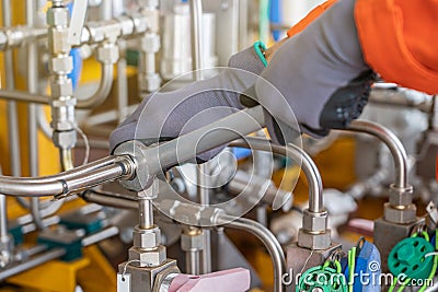 A mechanic operator fix and tighten stainless steel tubing system by using combination wrench Stock Photo