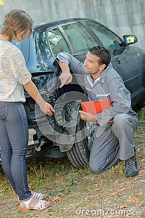 Mechanic pointing to damage on rear car Stock Photo