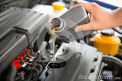 Mechanic pouring oil into car engine Stock Photo