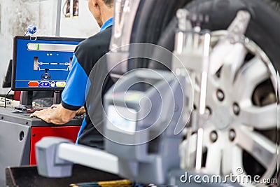 A mechanic reading the computer used to assess the wheel alignment process Stock Photo