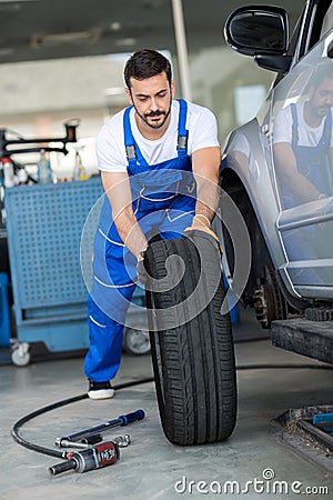 Mechanic repair and pushing a black tyre Stock Photo