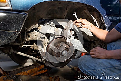 Mechanic repairing brake disk and detail of the wheel Stock Photo