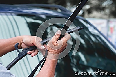 Mechanic replace windshield wipers on car. Replacing wiper blades Stock Photo