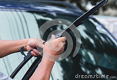 Mechanic replace windshield wipers on car. Replacing wiper blades Stock Photo