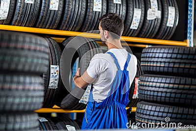 Mechanic sale a new tire for car Stock Photo