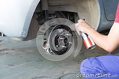 mechanic spray chemical to clean brake Stock Photo