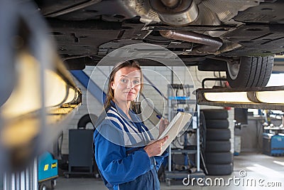 Mechanic underneath a car during a periodic examination Stock Photo