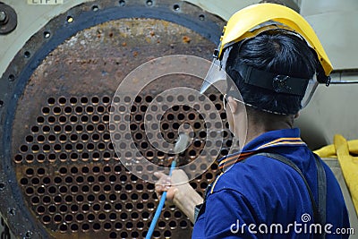 Mechanic is using brush to clean condenser tube of Chiller Editorial Stock Photo