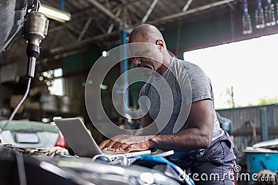 Mechanic using compute for Diagnostic machine tools ready to be used with car. Car mechanic using a computer laptop to diagnosing Stock Photo