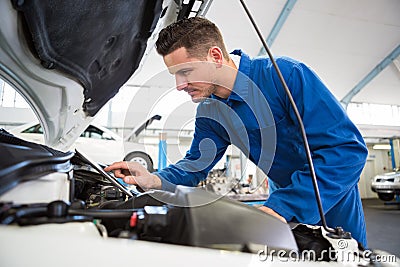 Mechanic using tablet to fix car Stock Photo