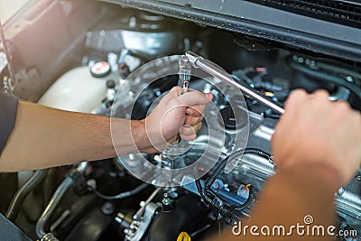 Mechanic working on car engine in auto repair shop Stock Photo